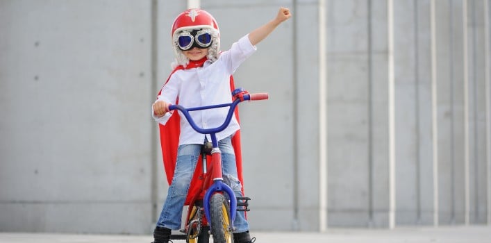 Kind Superman auf Fahrrad