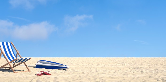 Urlaub im Sommer am Strand im Liegestuhl vor einem blauen Himmel