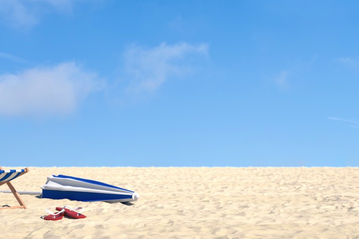 Urlaub im Sommer am Strand im Liegestuhl vor einem blauen Himmel