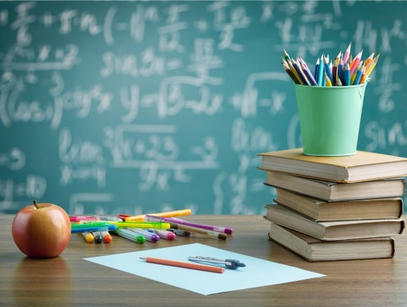 Schultafel mit Stiften, Bücher, Apfel