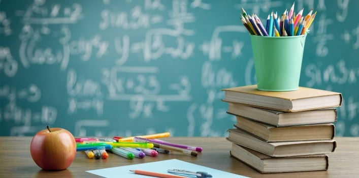 Schultafel mit Stiften, Bücher, Apfel