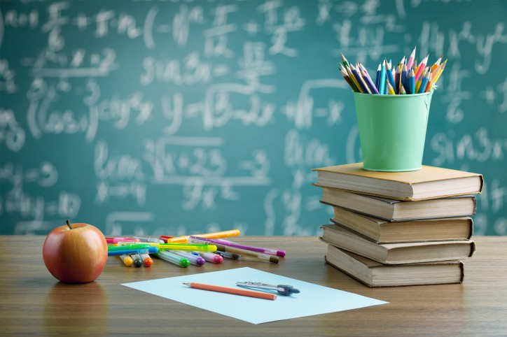 Schultafel mit Stiften, Bücher, Apfel