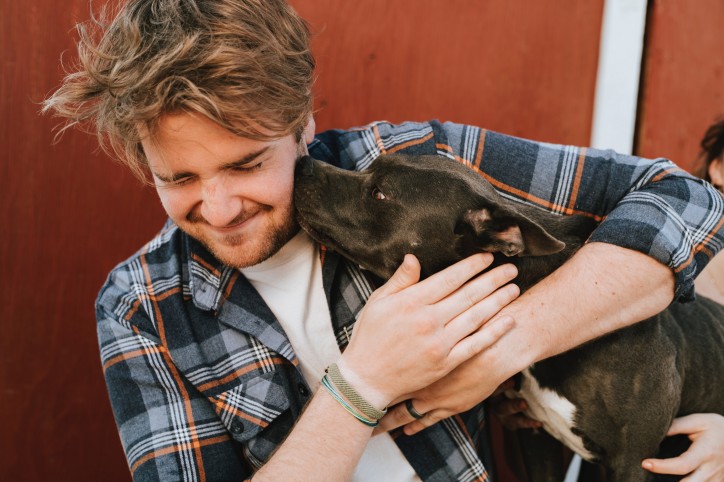 Hund schleckt Mann übers Gesicht