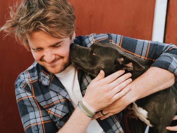 Hund schleckt Mann übers Gesicht