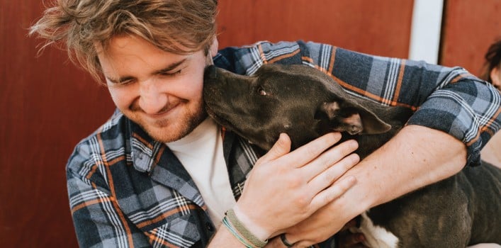 Hund schleckt Mann übers Gesicht